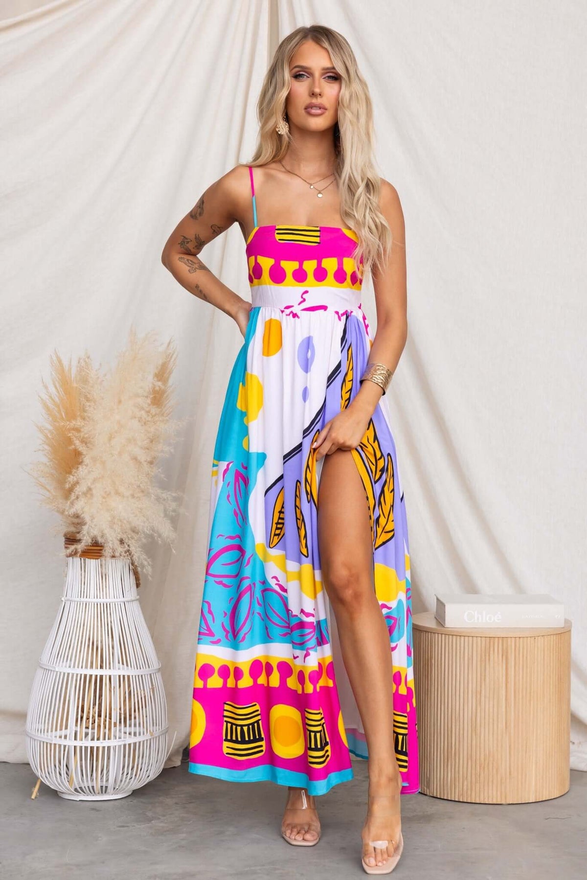 Model wearing Orella Maxi Dress featuring a vibrant print, adjustable straps, and high front split.