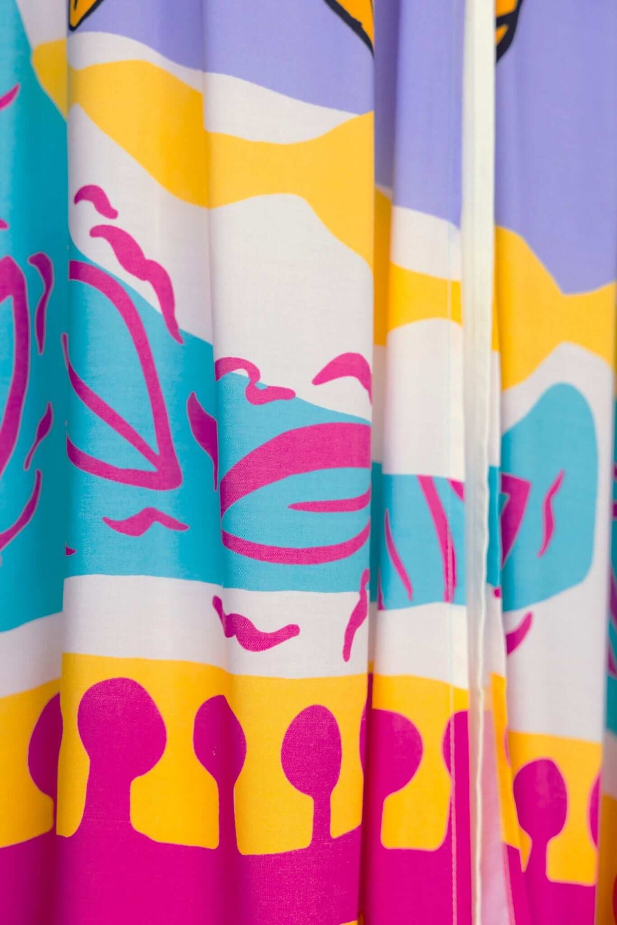 Colorful floral print of the Orella Maxi Dress featuring vibrant pink, turquoise, and yellow patterns on lightweight fabric.