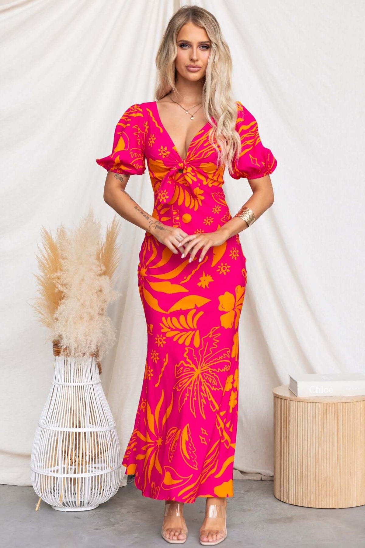 Nowah Maxi Dress in vibrant pink with floral design, featuring a tie bust and elastic cuffs, perfect for casual summer outings.