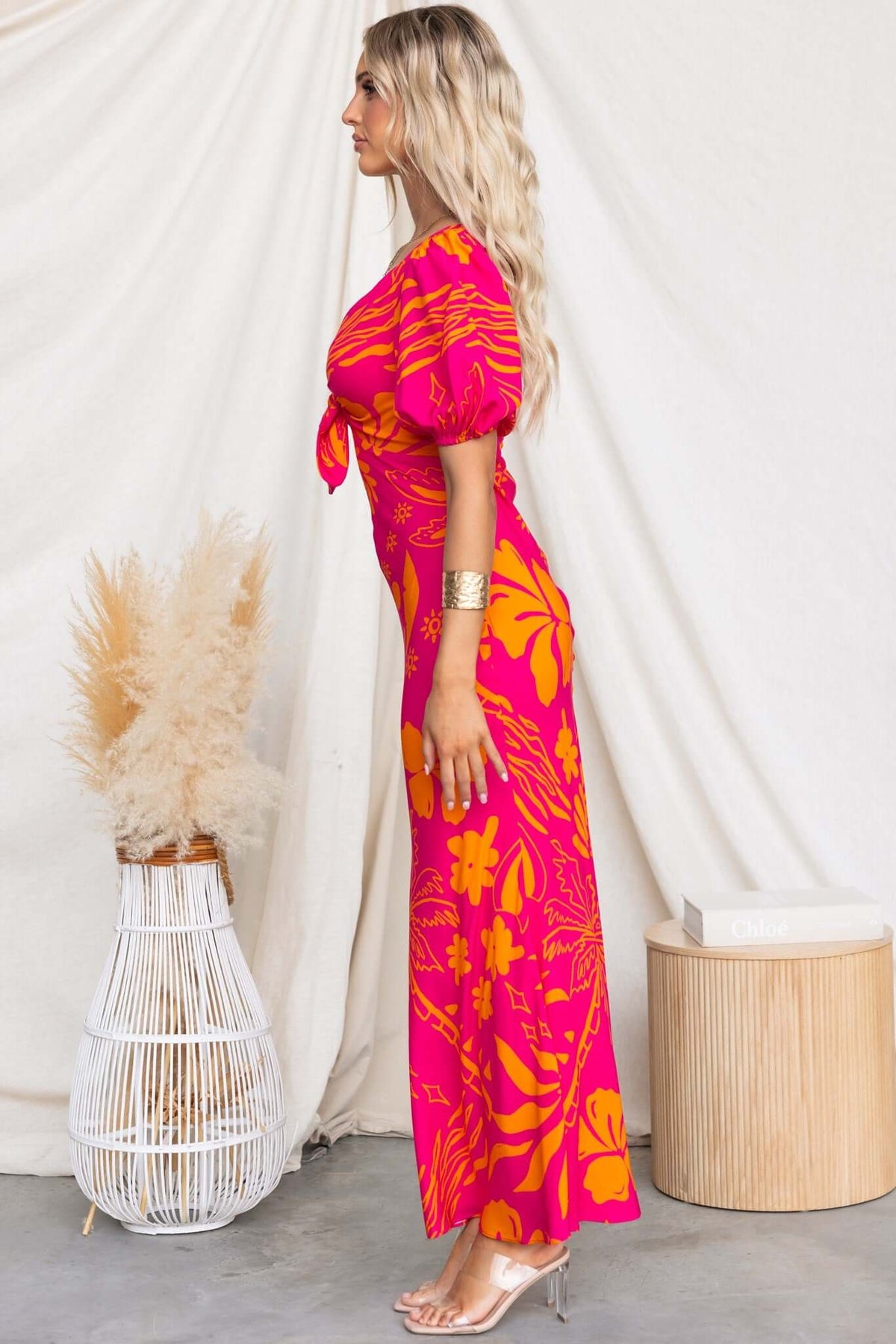 Nowah Maxi Dress in vibrant pink and orange, featuring a bust tie, elastic cuffs, and a flattering silhouette.