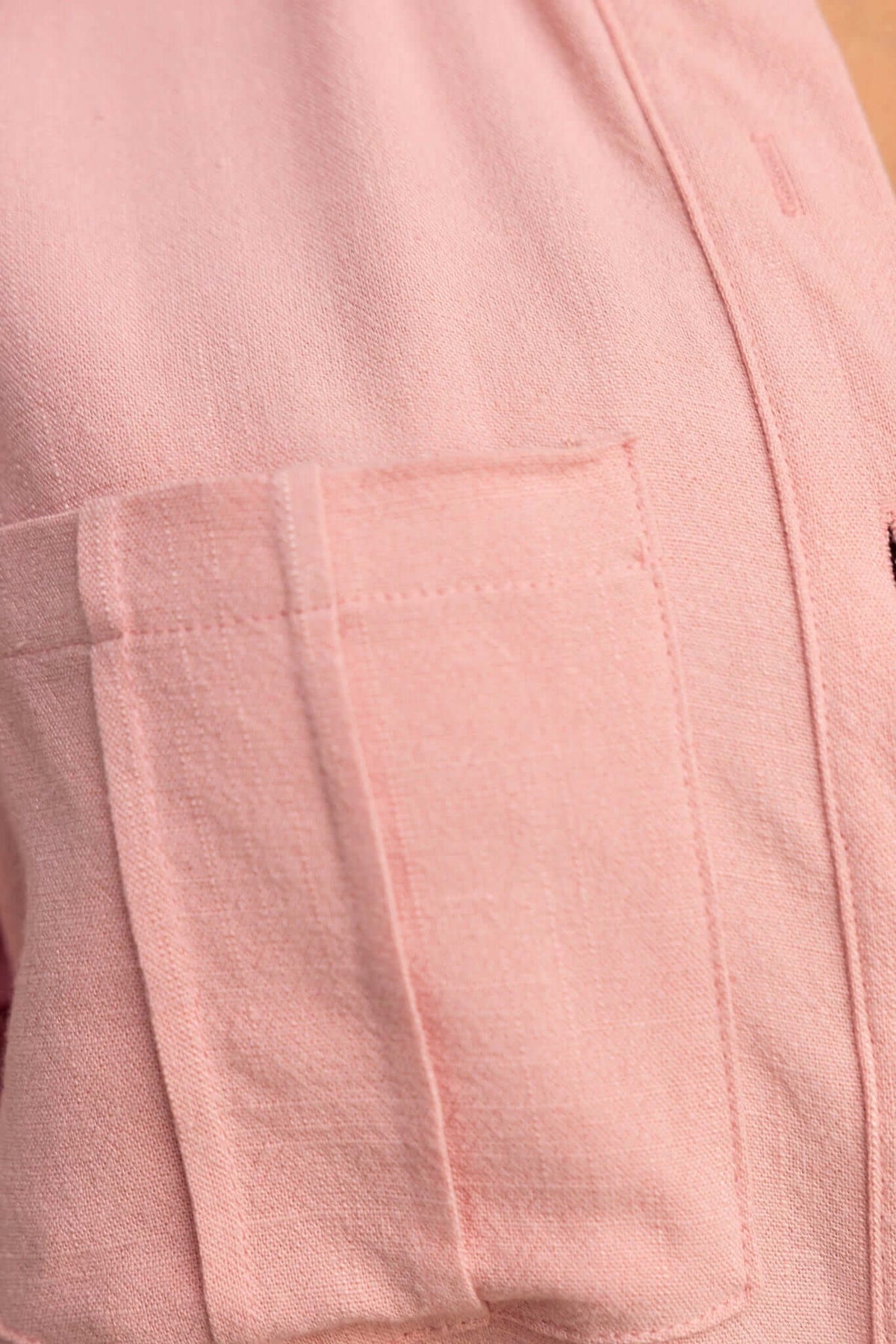Close-up of a pink fabric pocket on a relaxed-fit playsuit, showcasing its stylish design and casual appeal.