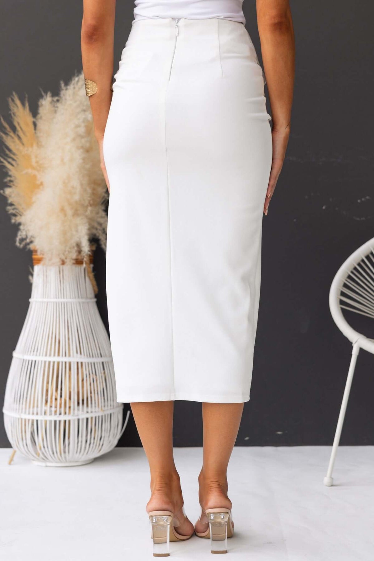 Hemmie Midi Skirt in white, showcasing a mid-high waist and sleek silhouette with a split at the side.