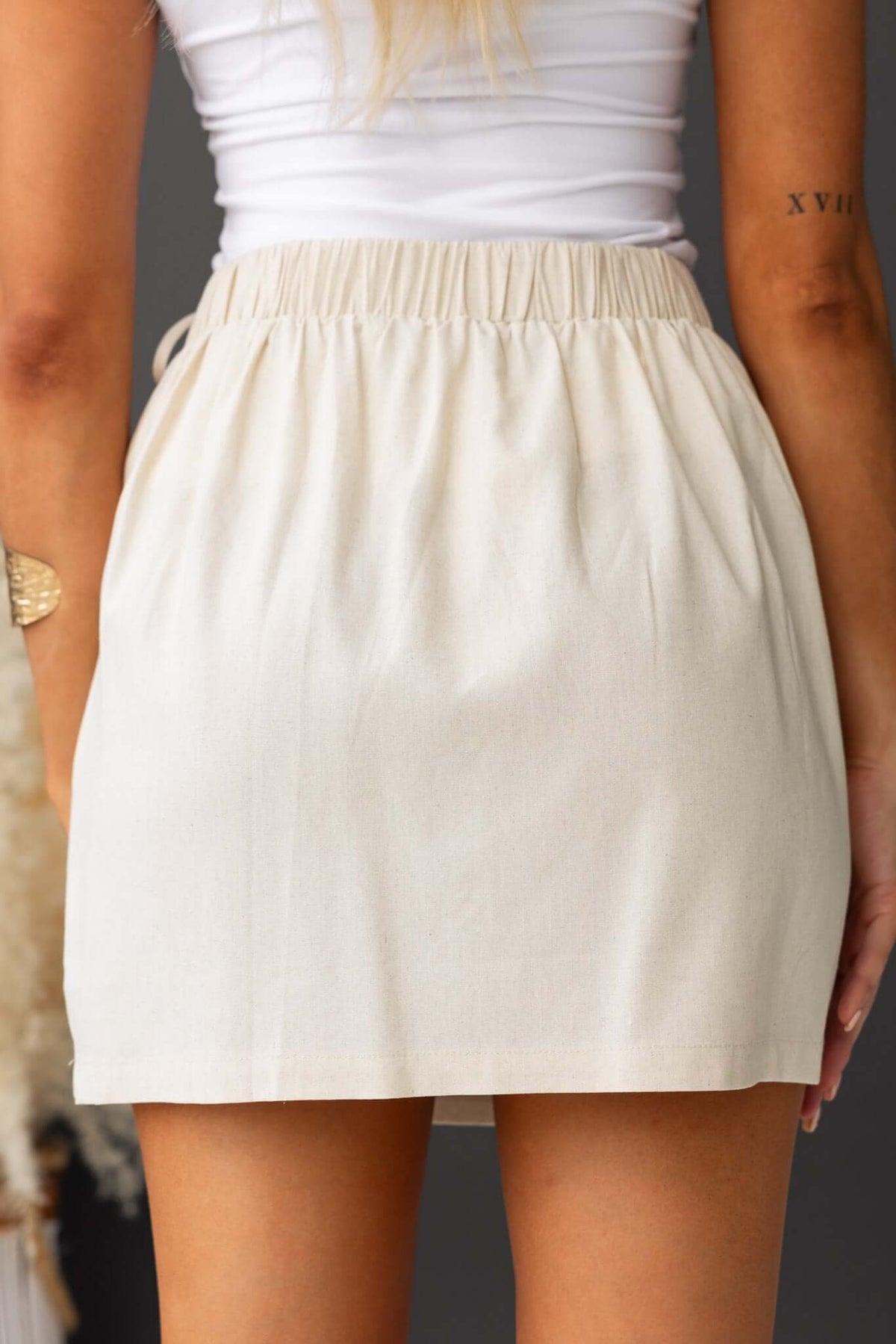 Back view of a light beige Quatro Skirt showcasing mid-high waist fit and elastic waistband.