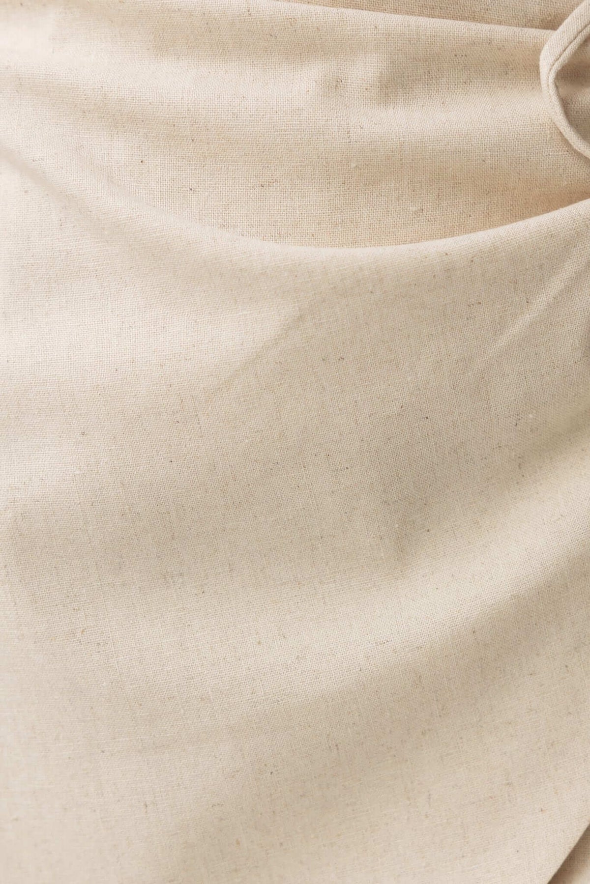 Close-up of beige fabric showing texture of Quatro Skirt's linen and polyester blend material.