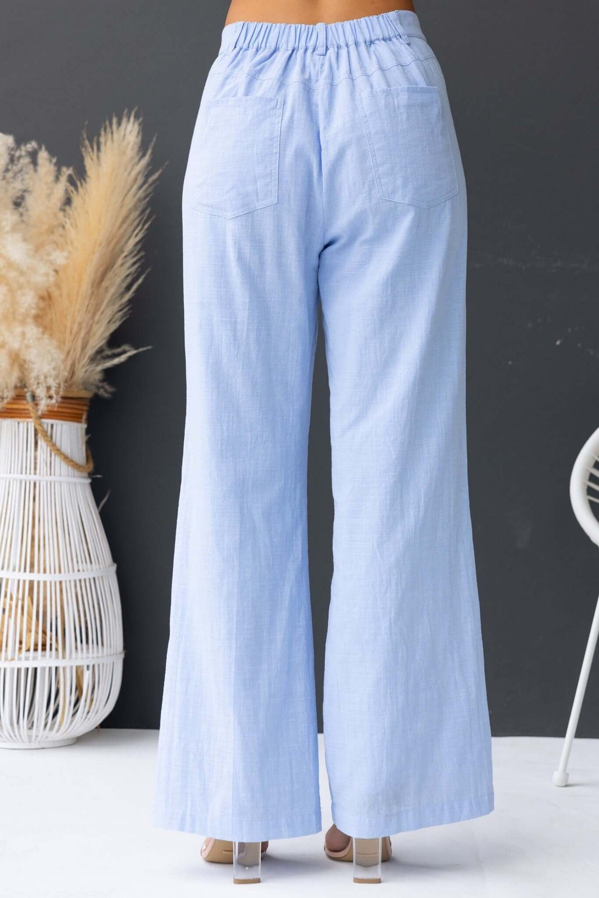 Asuka Pants: Light blue wide-leg pants with mid-high waist, elastic waistband, and pockets, perfect for casual wear.