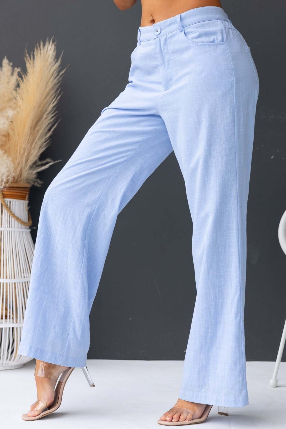 Light blue Asuka pants featuring a mid-high waist, elastic waistband, and pockets for a stylish look.