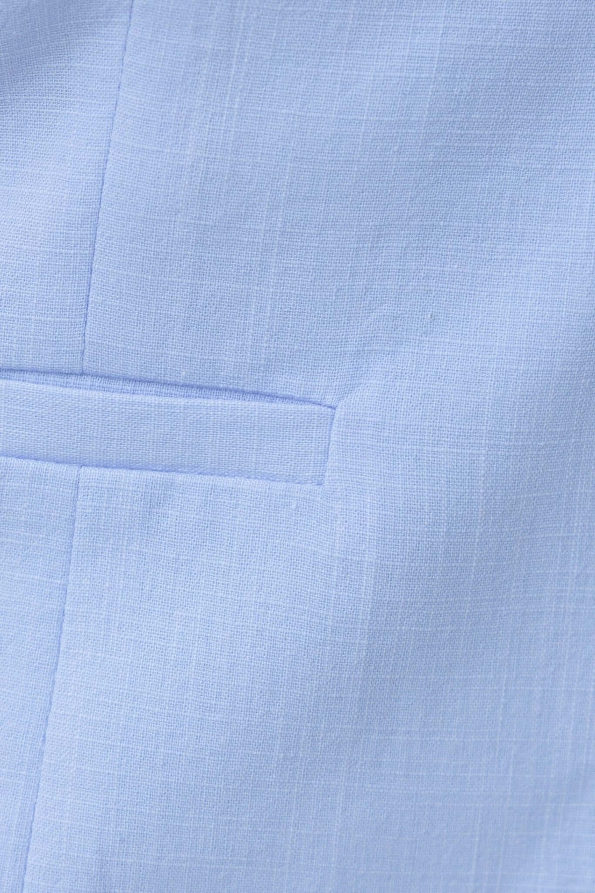 Close-up of the light blue fabric featuring a pocket detail, showcasing the texture and quality of the material.