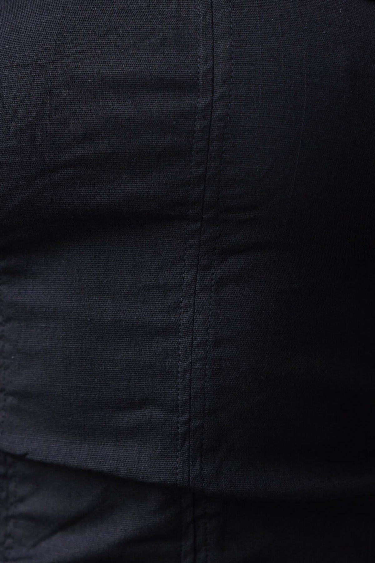 Close-up of the textured fabric of a black strapless Gomez dress, showcasing its linen and cotton blend.