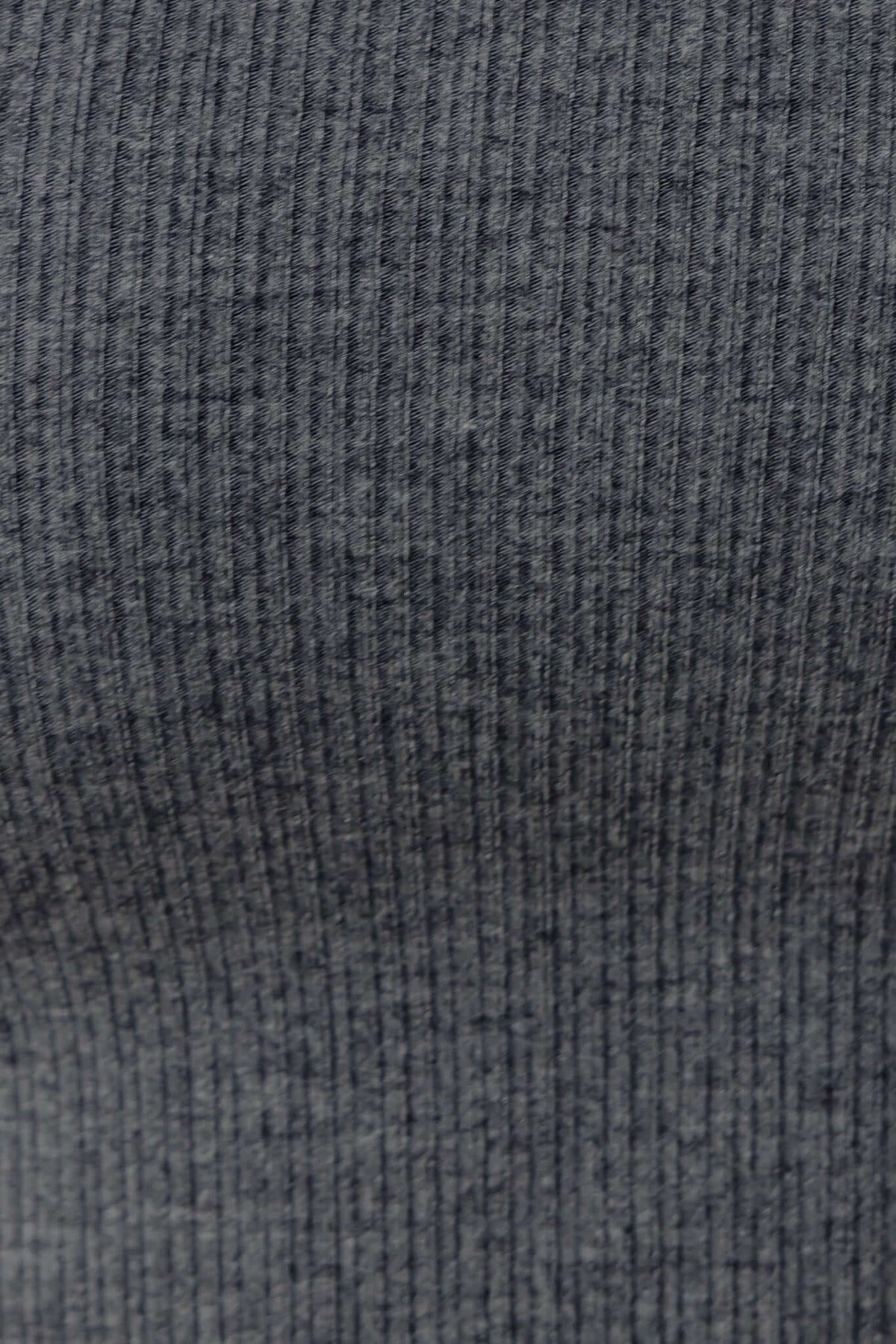 Close-up of ribbed material in dark gray, showcasing texture for the Gapita Top. Soft and stretchy fabric detail.