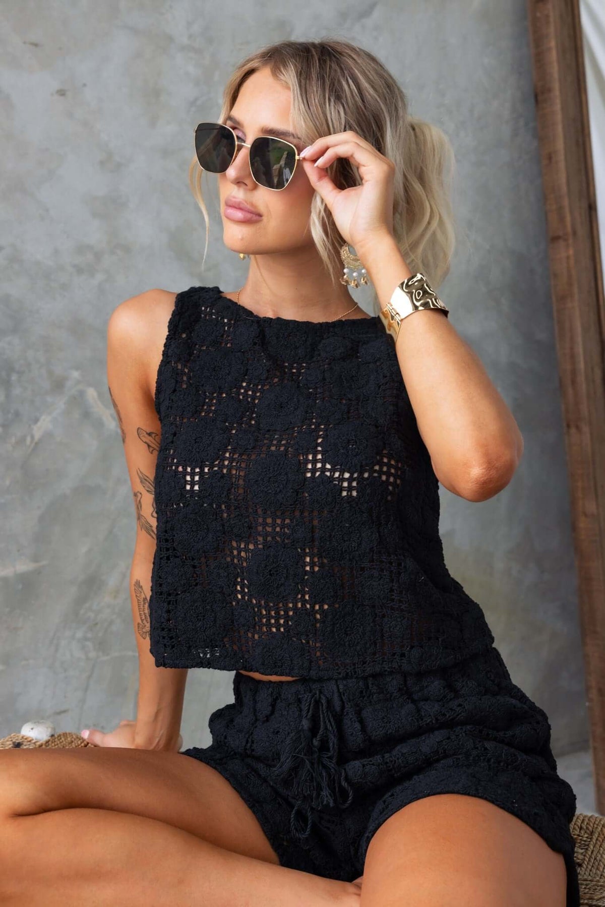 Model wearing a black lace Fenny Top with sunglasses, showcasing a stylish summer look.