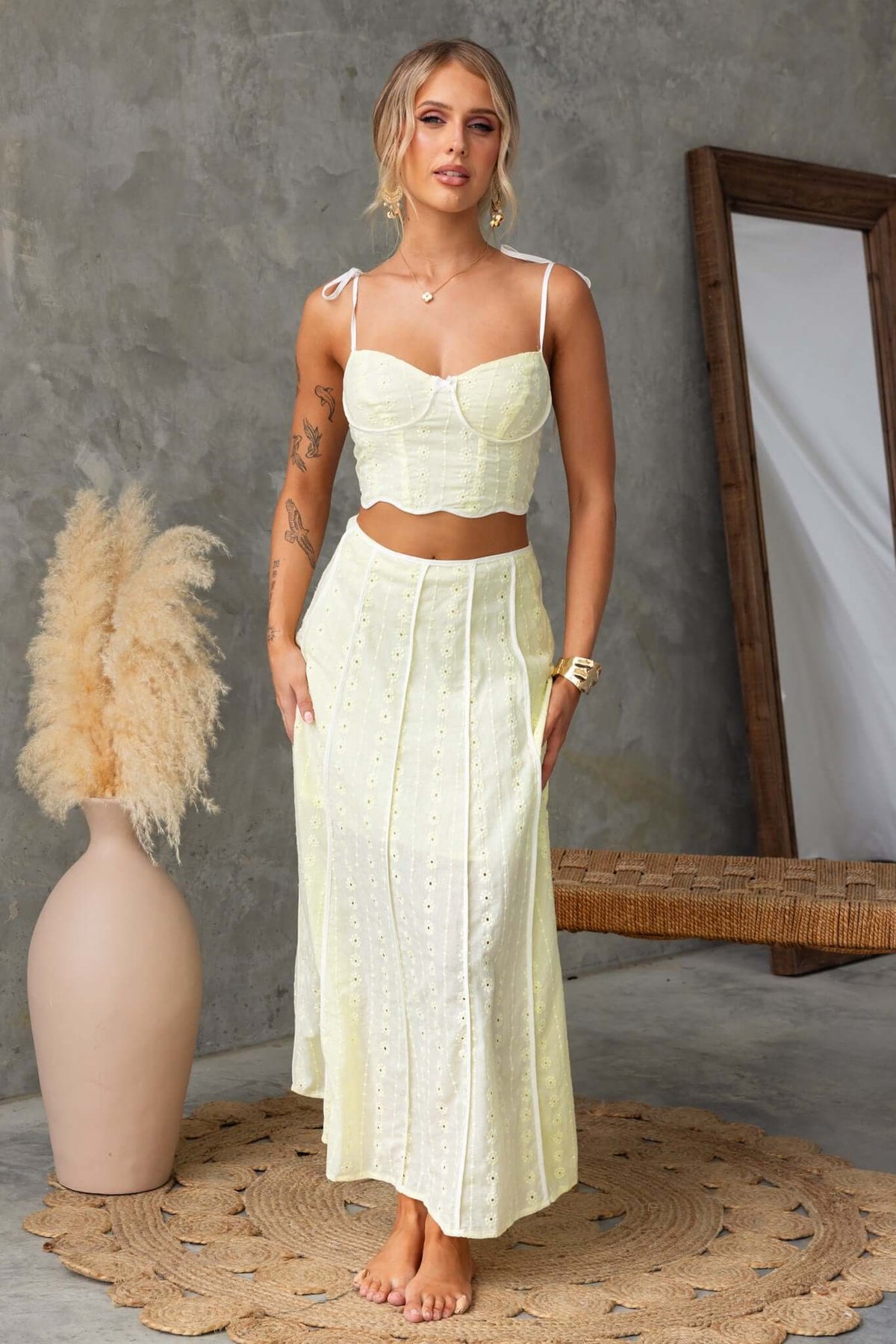 Model wearing a light yellow Honey Set with a cropped top and maxi skirt, featuring tie straps and an Anglaise pattern.