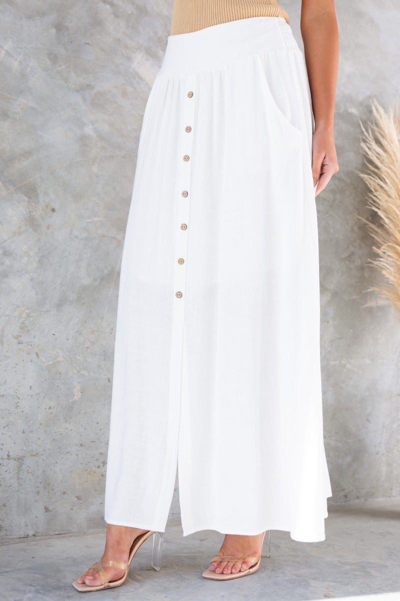 Dalila Maxi Skirt in white linen with elastic waist, button front, pockets, and front slit for a stylish summer look.
