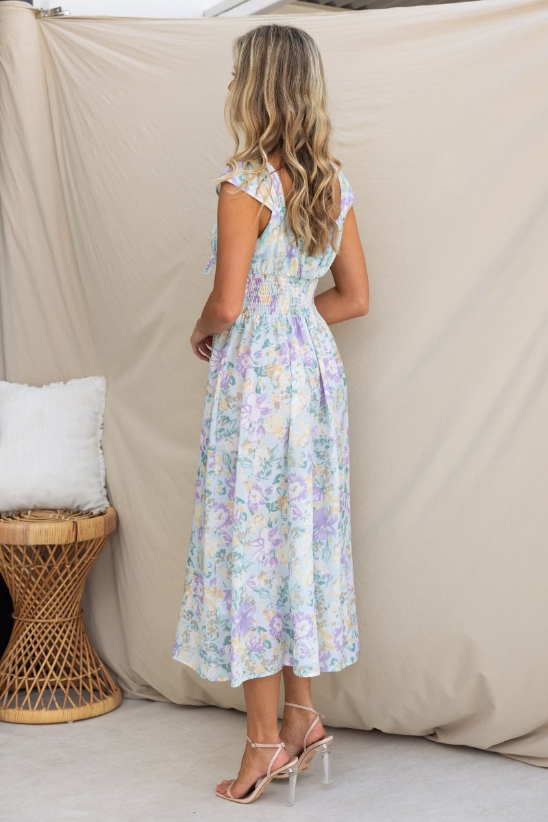 Back view of the Sweet Nothing Midi Dress featuring a floral print, tie detail at bust, and an elastic waistband.
