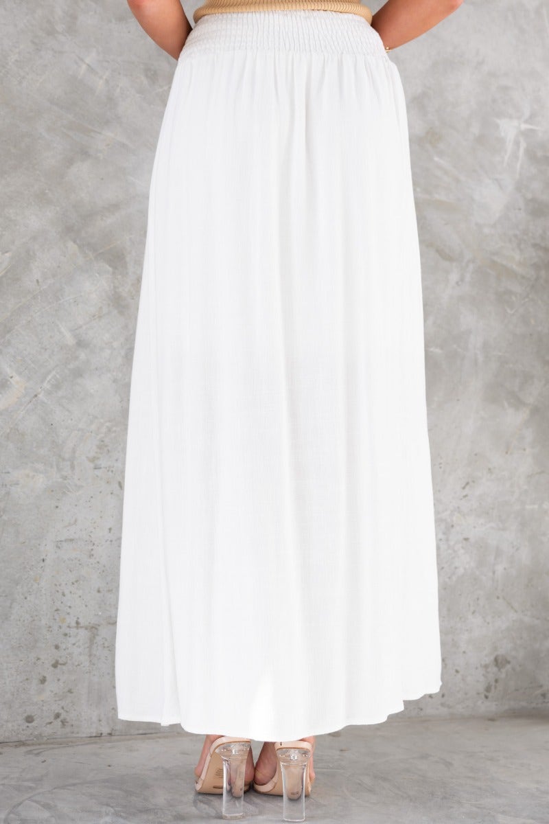 Back view of Dalila Maxi Skirt in white linen, featuring elastic waistband and flowy silhouette.