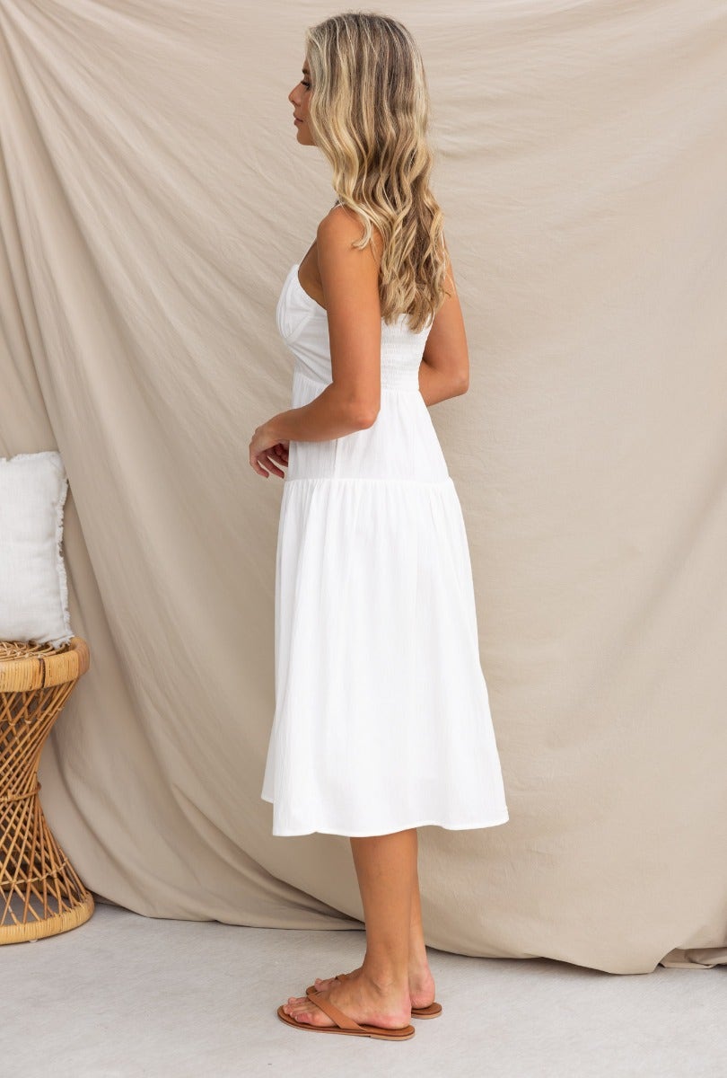 Side view of a woman wearing the Ramilah Cotton Midi Dress with adjustable straps, shown against a neutral backdrop.