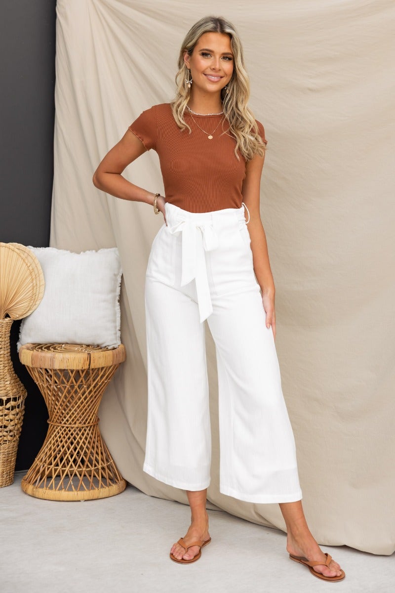 Woman wearing Chance Pants with removable tie, styled with a brown top, showcasing a chic and casual look.