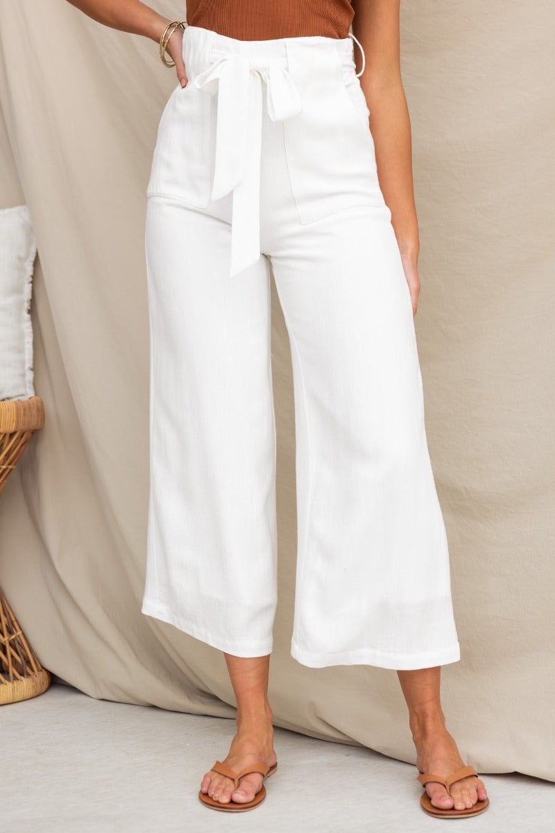Chance Pants in white linen, featuring a mid-high waist, removable tie, and spacious pockets for a stylish and comfortable fit.