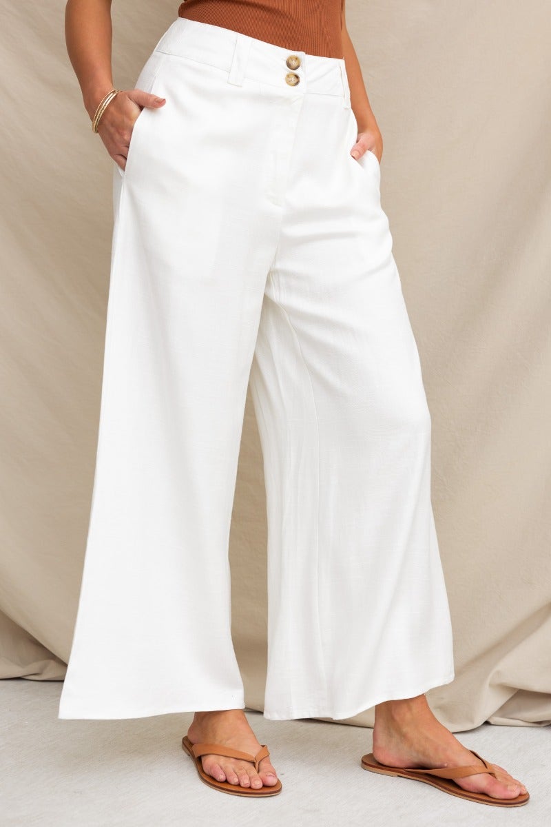 Stylish silk blend wide-leg pants in white with a mid-high waist and pockets, perfect for a fashionable summer look.