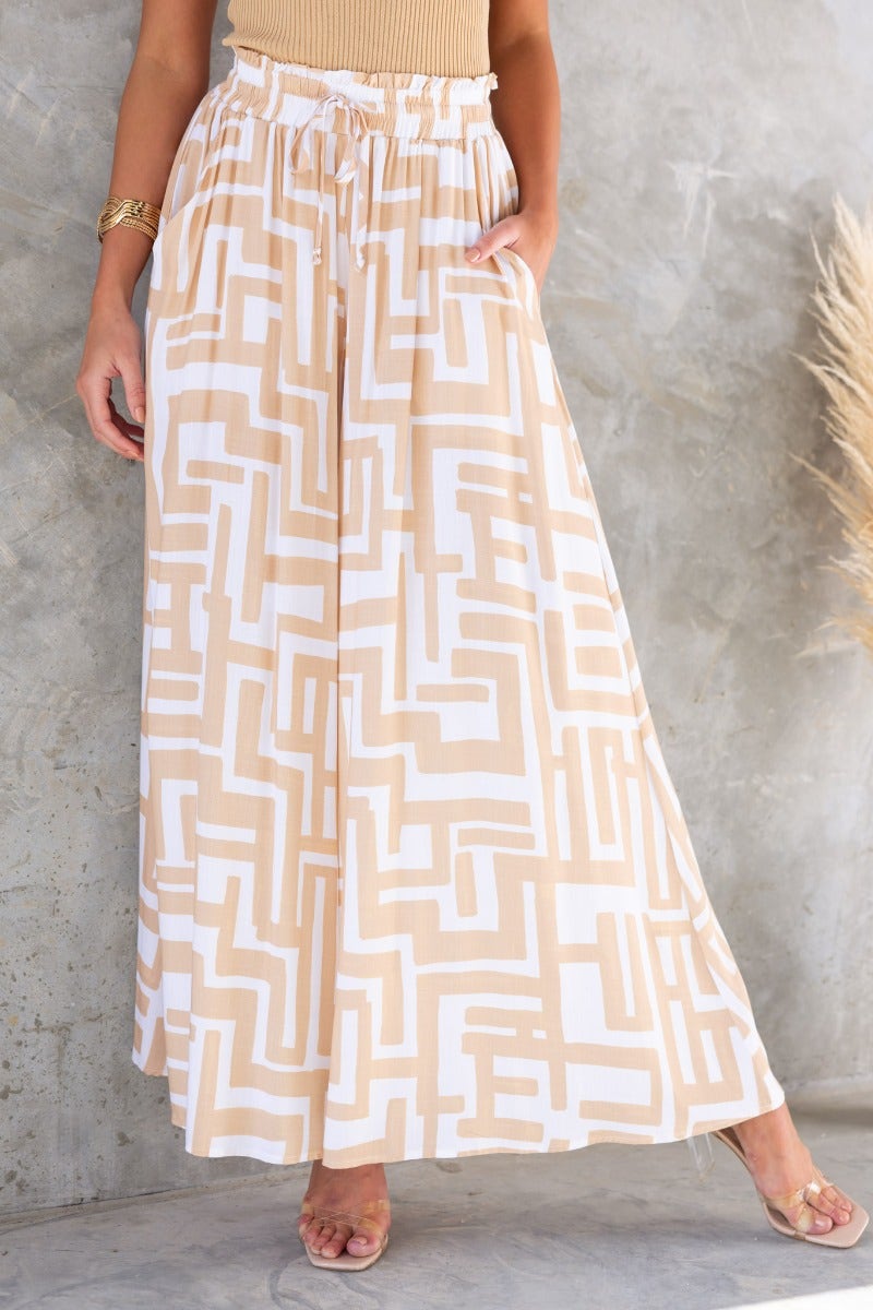 Esmie Pants: Stylish beige patterned print pants with elastic waistband and drawstring, perfect for casual wear.