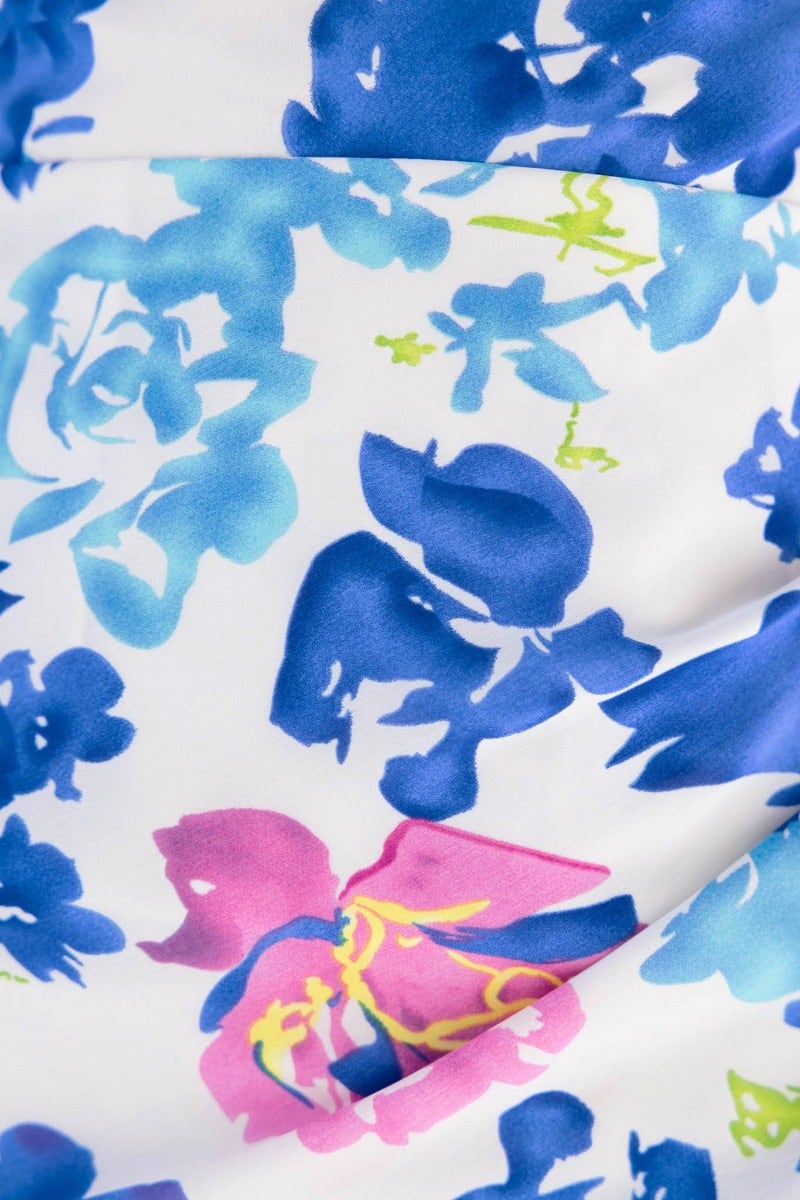 Close-up of floral print fabric in blue and pink, featuring vibrant roses, ideal for a glistening maxi dress.