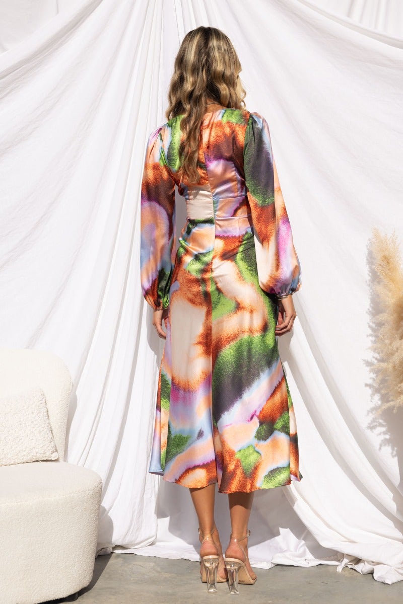 Model wearing the Milani Midi Dress, showcasing colorful satin fabric and elegant cut-out design from the back.