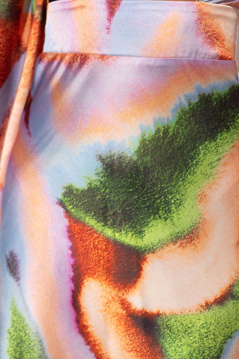 Close-up of Milani Midi Dress fabric with colorful abstract patterns in vibrant tones of orange, green, and blue.