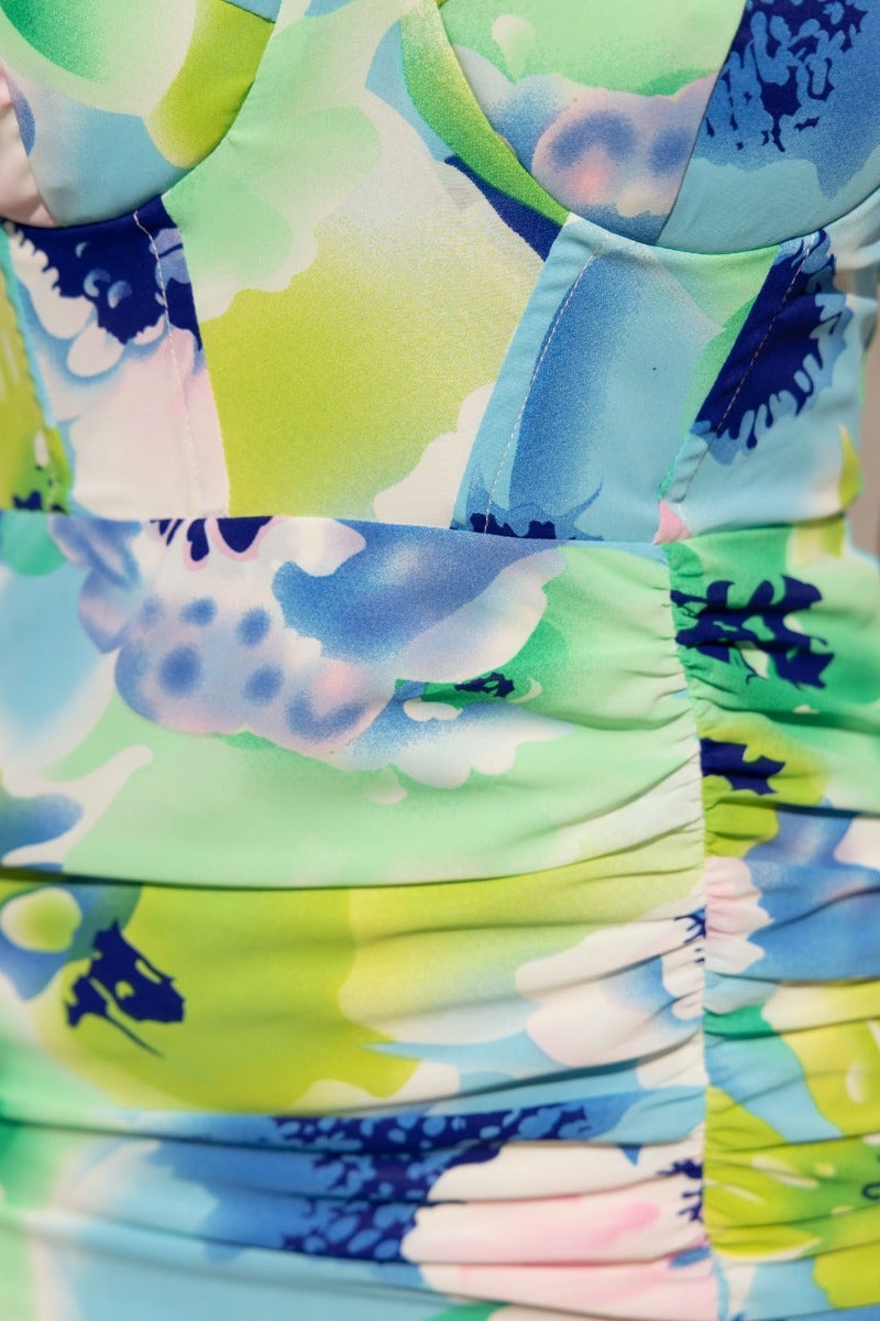 Floral print fabric detail of the Zephyr Midi Dress showcasing ruched design and vibrant colors.