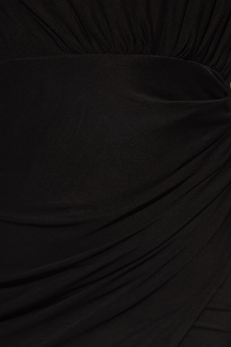 Close-up of black midi dress fabric showcasing twist detail and draping material for a stylish look.
