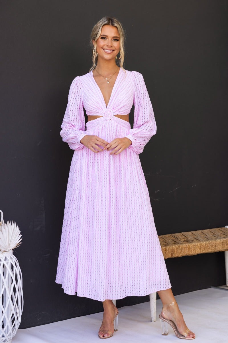 Model wearing a stylish Devine Maxi Dress in pink with an open plunge neckline and elegant ring detail.