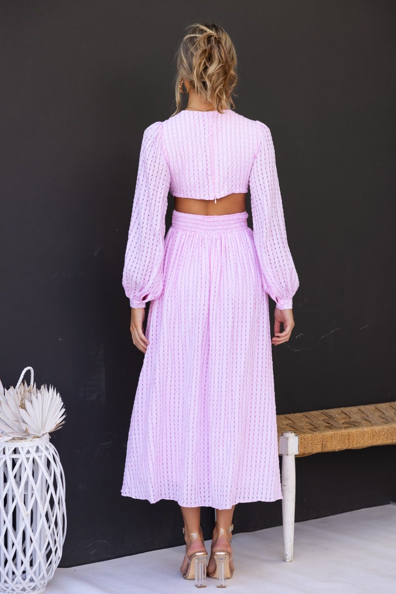 Back view of Devine Maxi Dress in textured pink material with open plunge neckline and cut-out waist.
