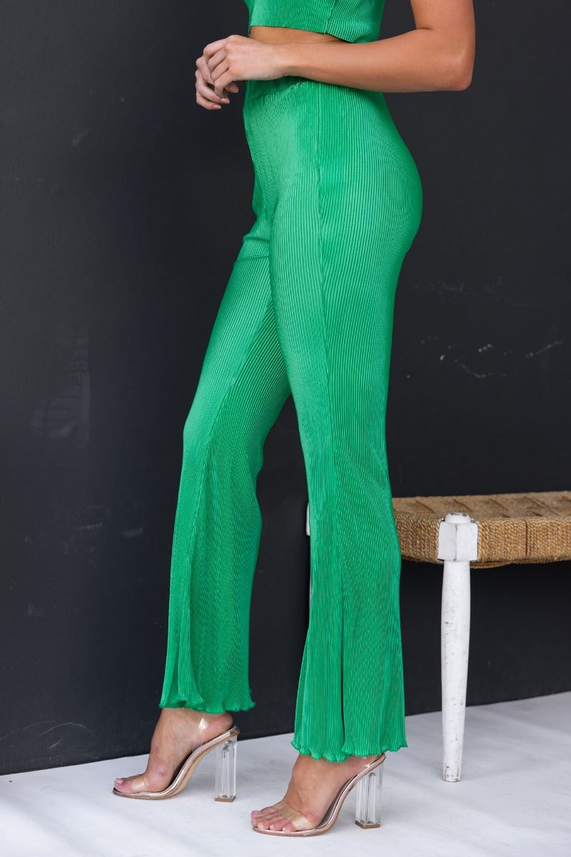 Green accordion pleat pants with an elastic waistband, perfect for a stylish summer look.