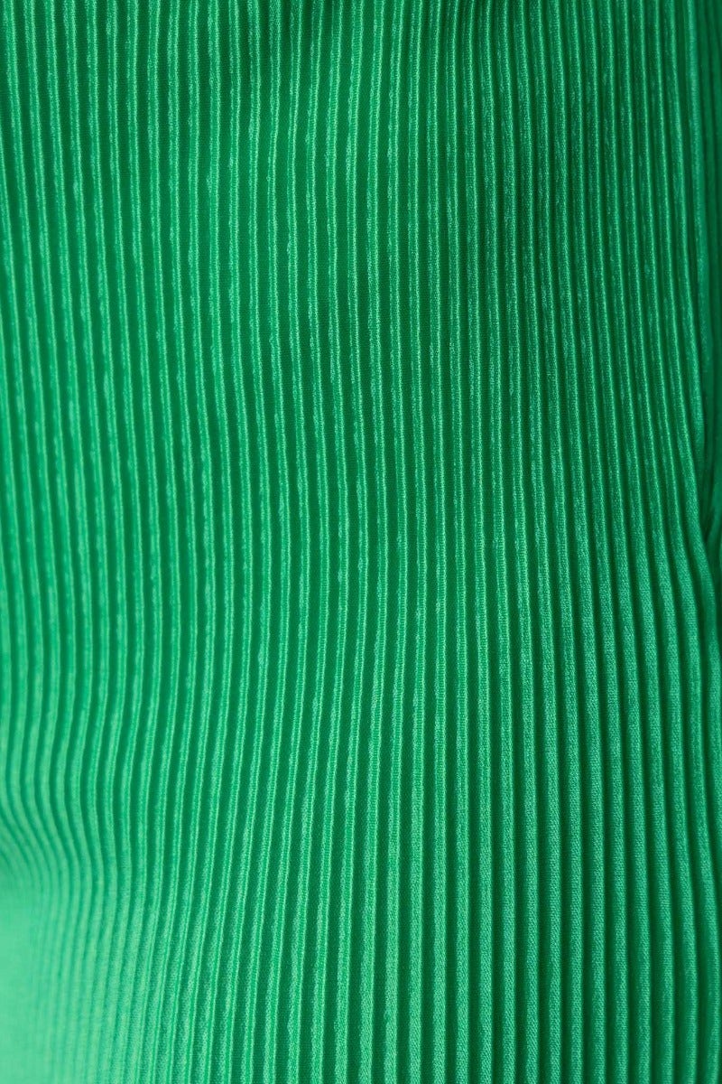 Close-up view of green accordion pleated fabric, showcasing its texture and stretch for the Harvie Top.