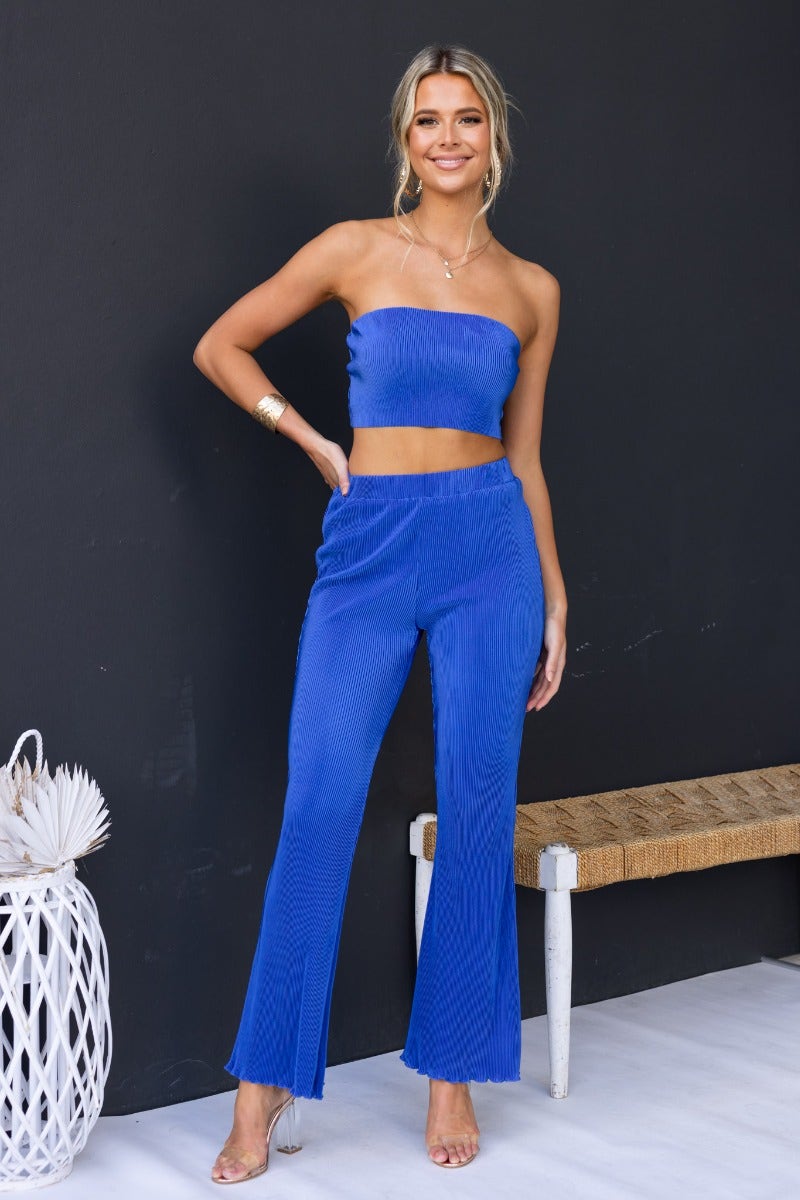 Model wearing Harvie Pants, a strapless elastic top and pleated blue pants, showcasing a stylish casual look.