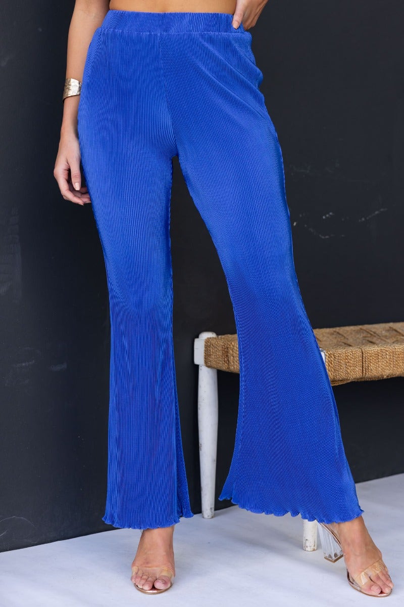 Stylish Harvie Pants in vibrant blue with flared bottoms and accordion pleats, perfect for a casual outfit.