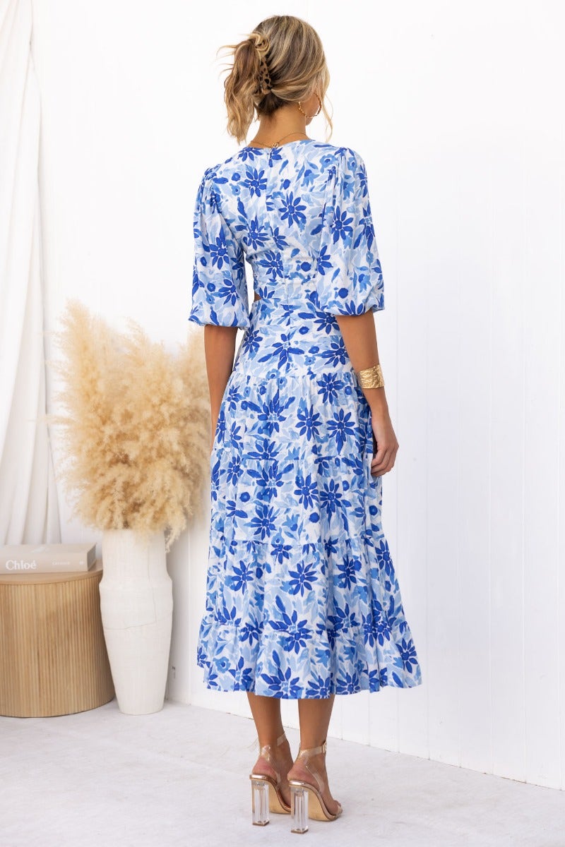 Back view of the Abeila Maxi Dress with blue floral print, V-neckline, and cut-out at waist.