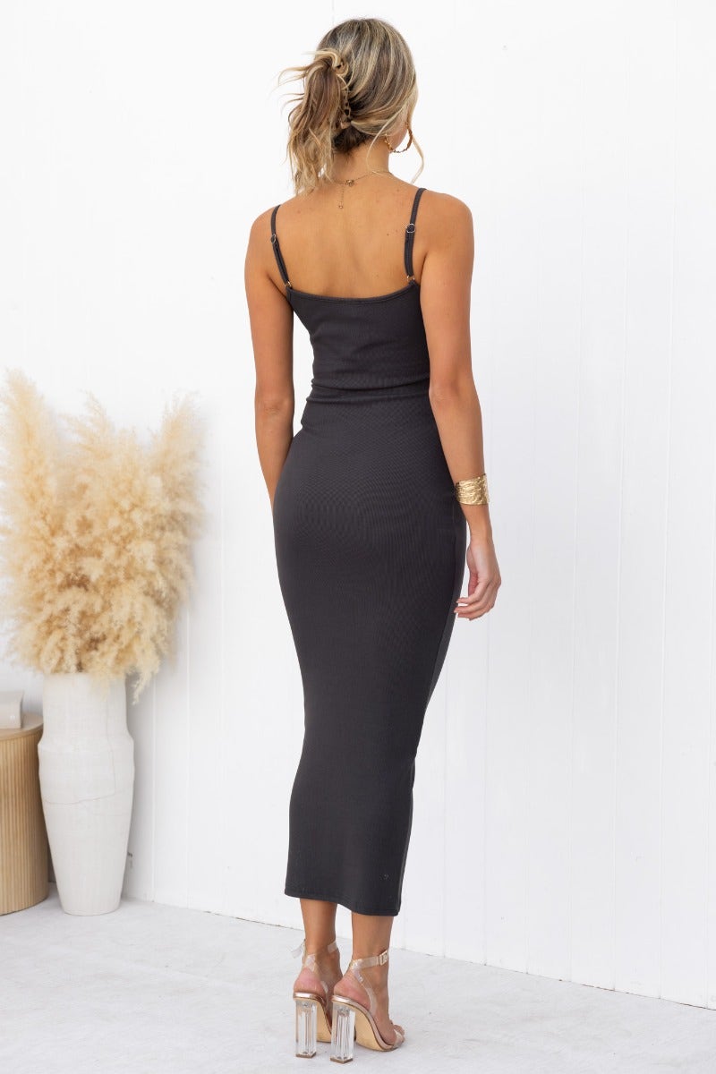 Back view of woman wearing dark grey ribbed Naira midi dress with adjustable straps.