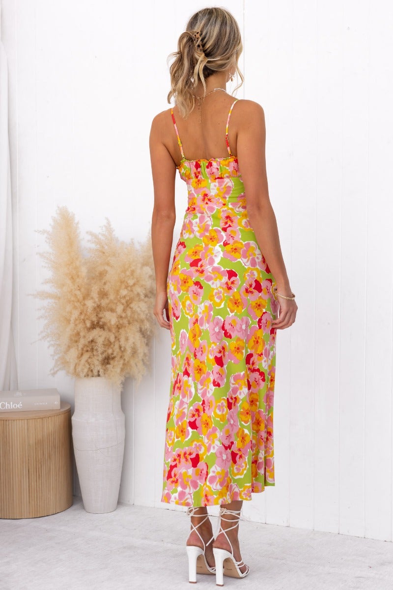 Back view of a floral maxi dress with adjustable straps, featuring a vibrant yellow, pink, and green pattern.