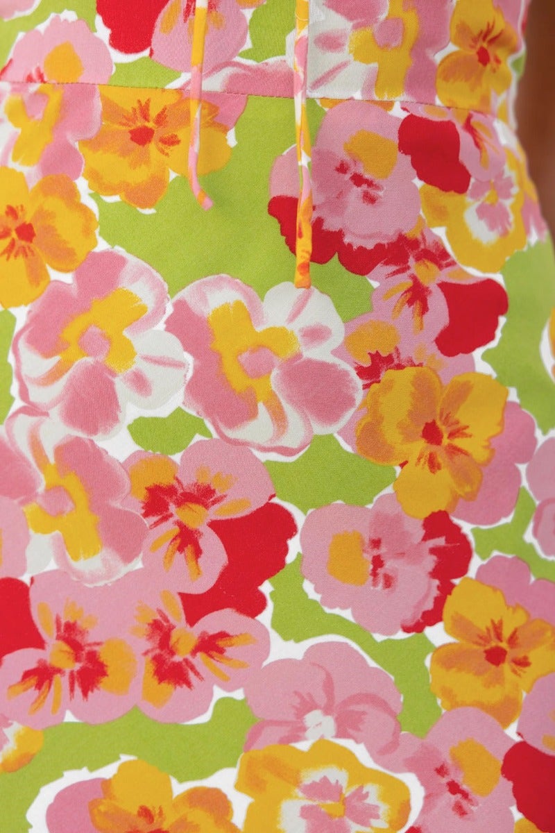 Vibrant floral pattern in pink, yellow, and red on a green background for an uplifting maxi dress.