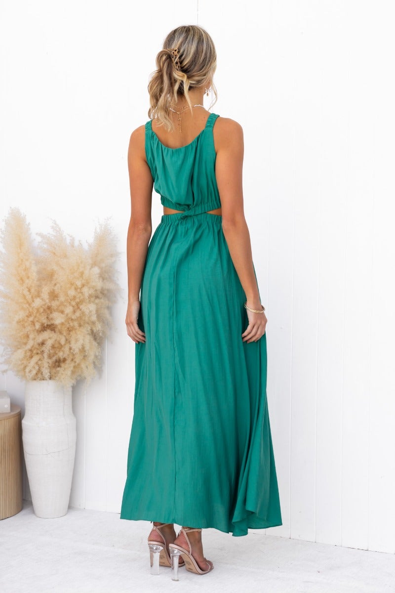 Back view of Silvena Maxi Dress in green, featuring a cut-out waist, high neckline, and flowing fabric.
