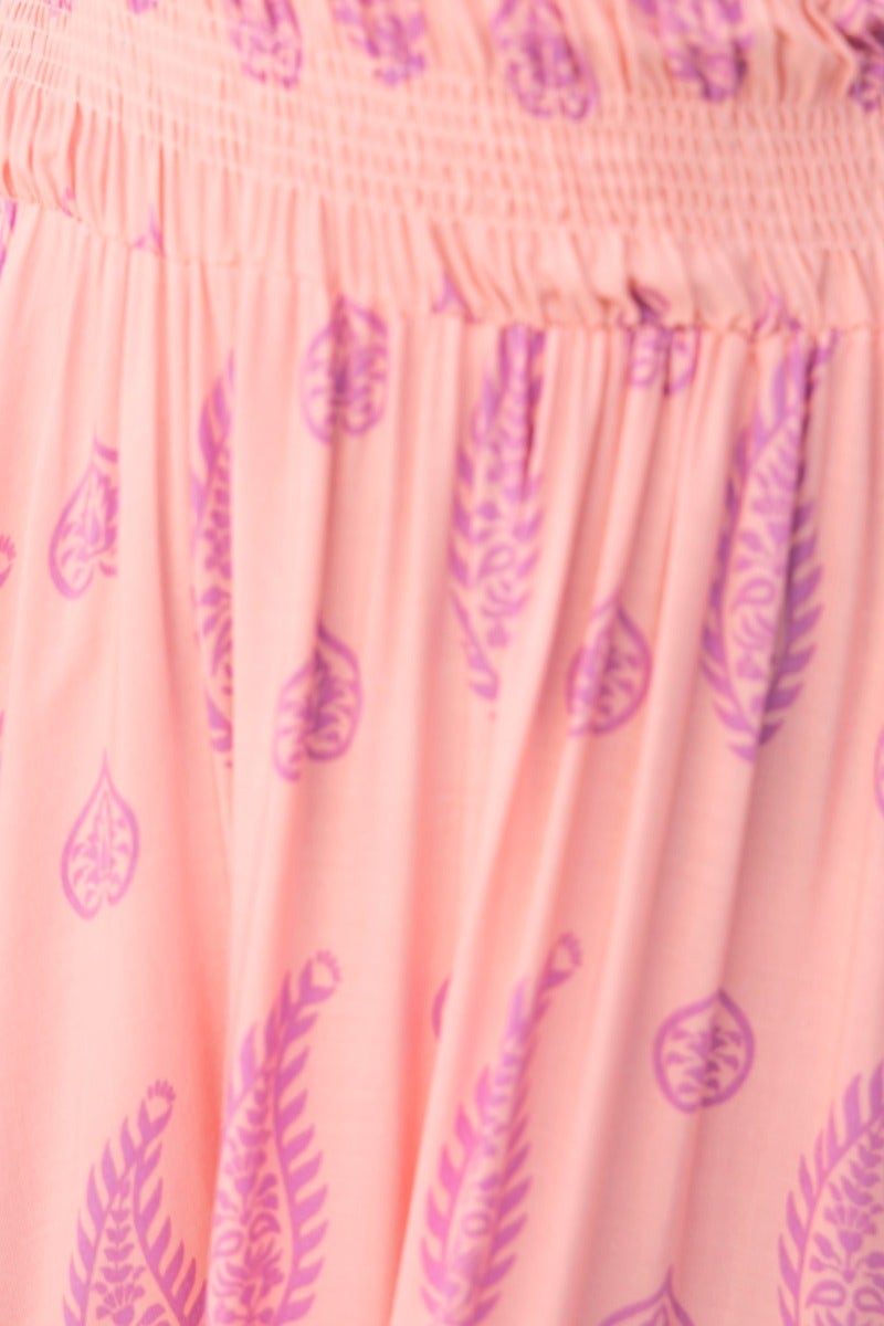 Close-up of the Right Time Maxi Dress in soft pink with purple leaf patterns, showcasing its elastic bodice and flowing fabric.