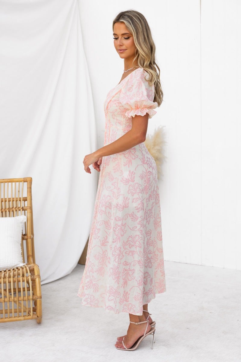 Model wearing Adaline Maxi Dress, a floral V-neckline dress with puff sleeves and a mid-thigh lining, styled elegantly.