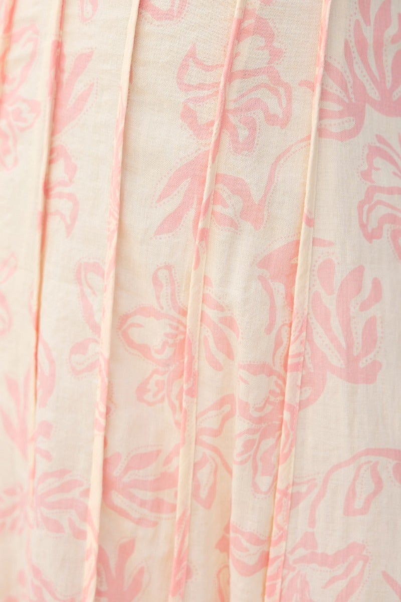 Close-up of Adaline Maxi Dress featuring soft floral print in pink on a light fabric background.