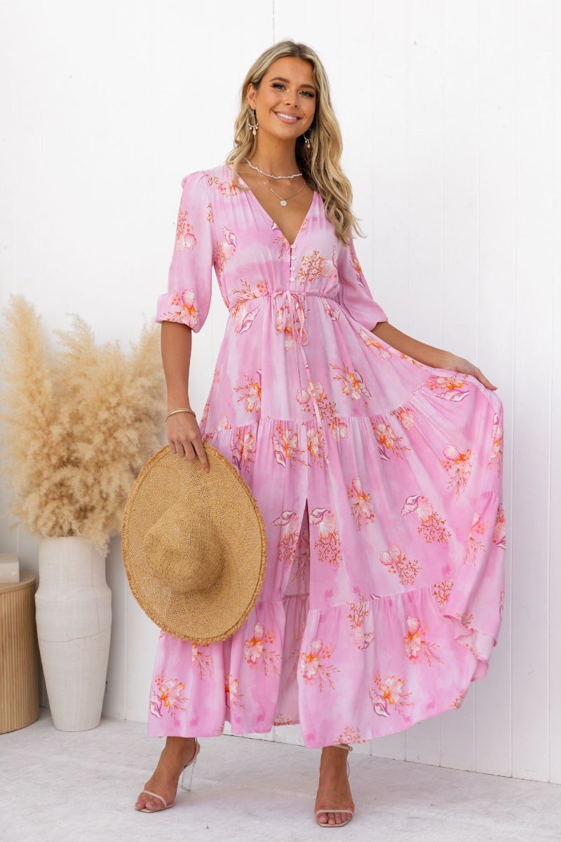 Model wearing a pink floral print Yespia maxi dress with V-neckline and adjustable waist.