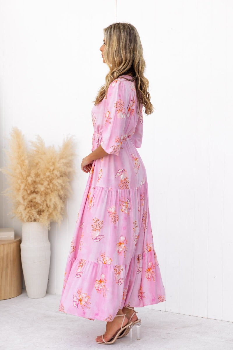 Profile view of a woman in a floral print Yespia maxi dress with V-neckline and adjustable waist.