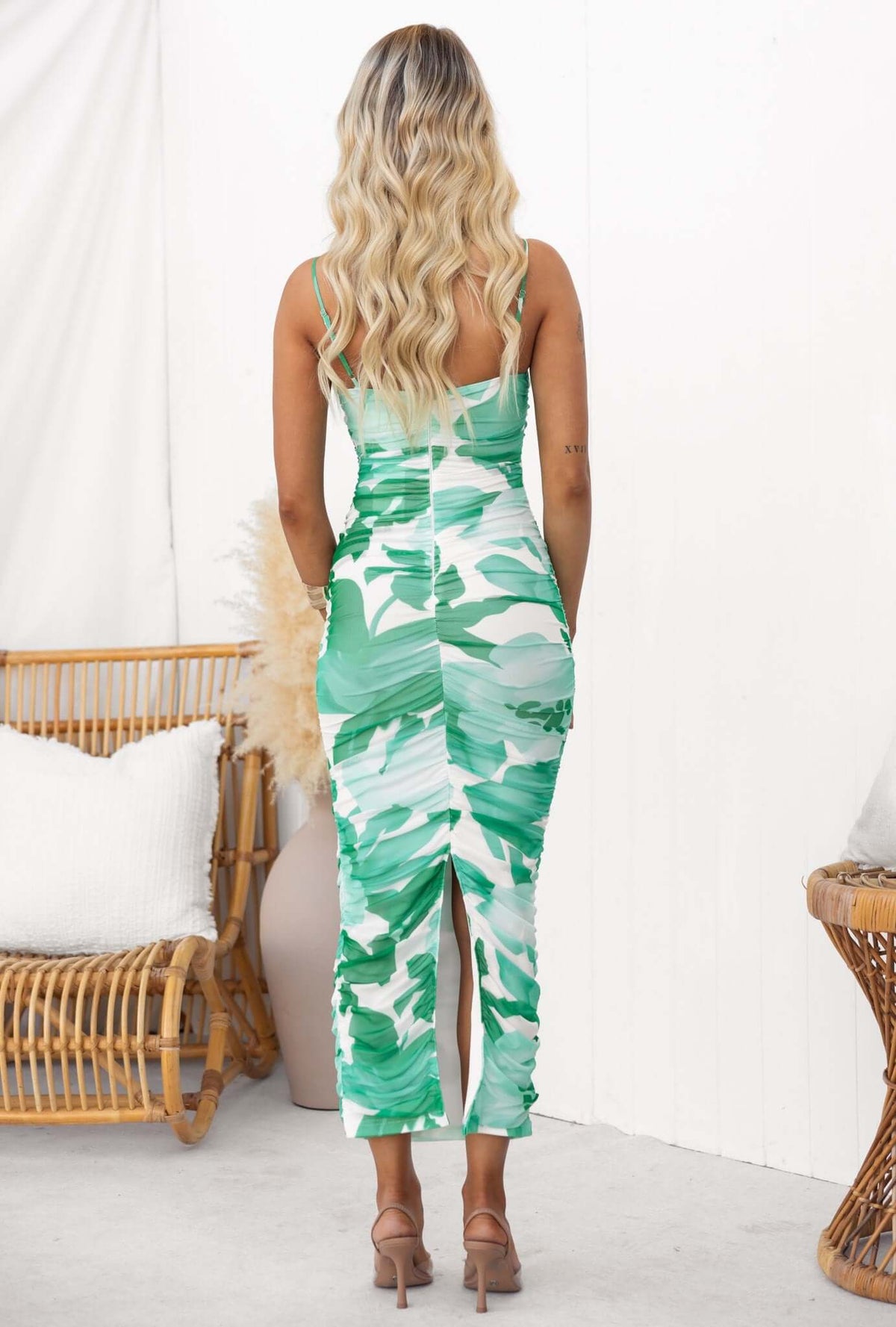 Back view of Oaklyn Maxi Dress showcasing adjustable spaghetti straps and split detail, styled in a green abstract pattern.
