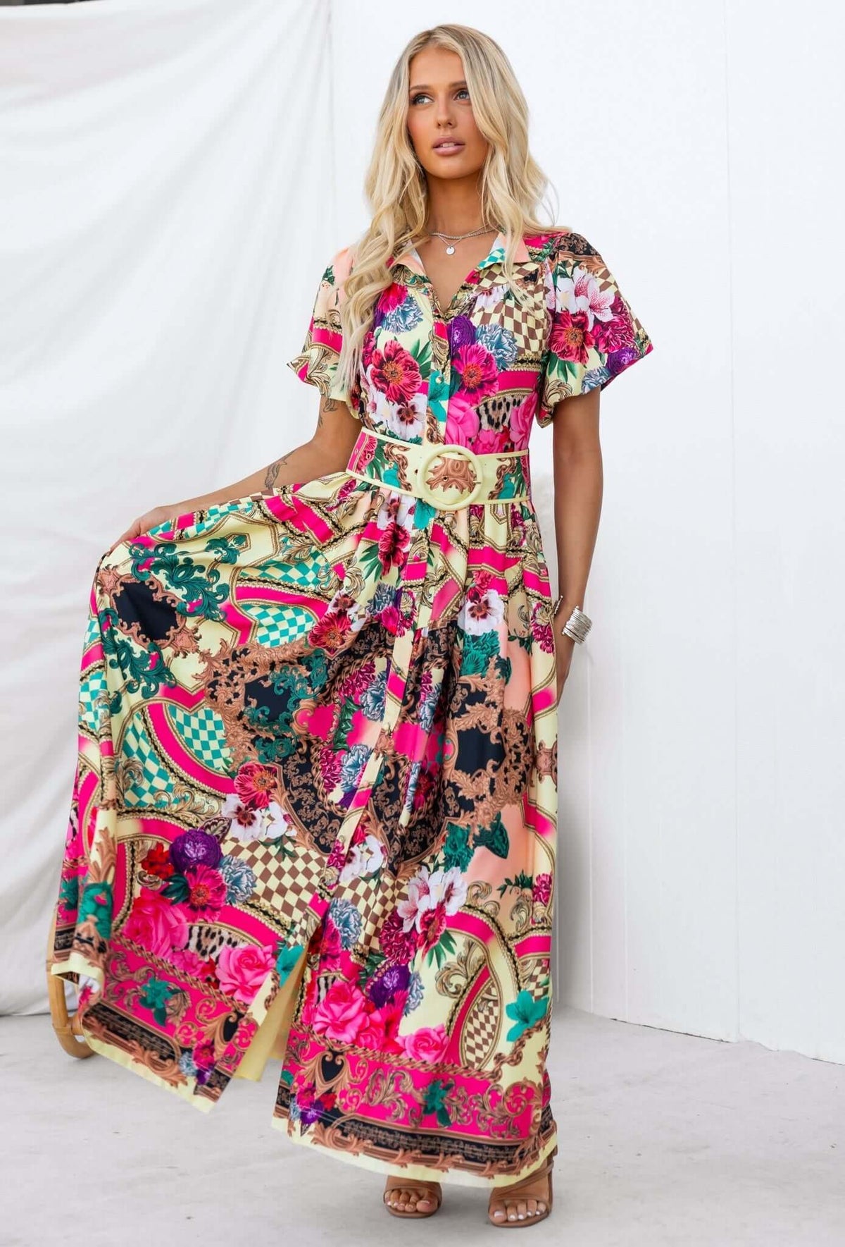 Woman modeling the colorful Palermo Maxi Dress with a floral print, button-down front, and removable fabric belt.