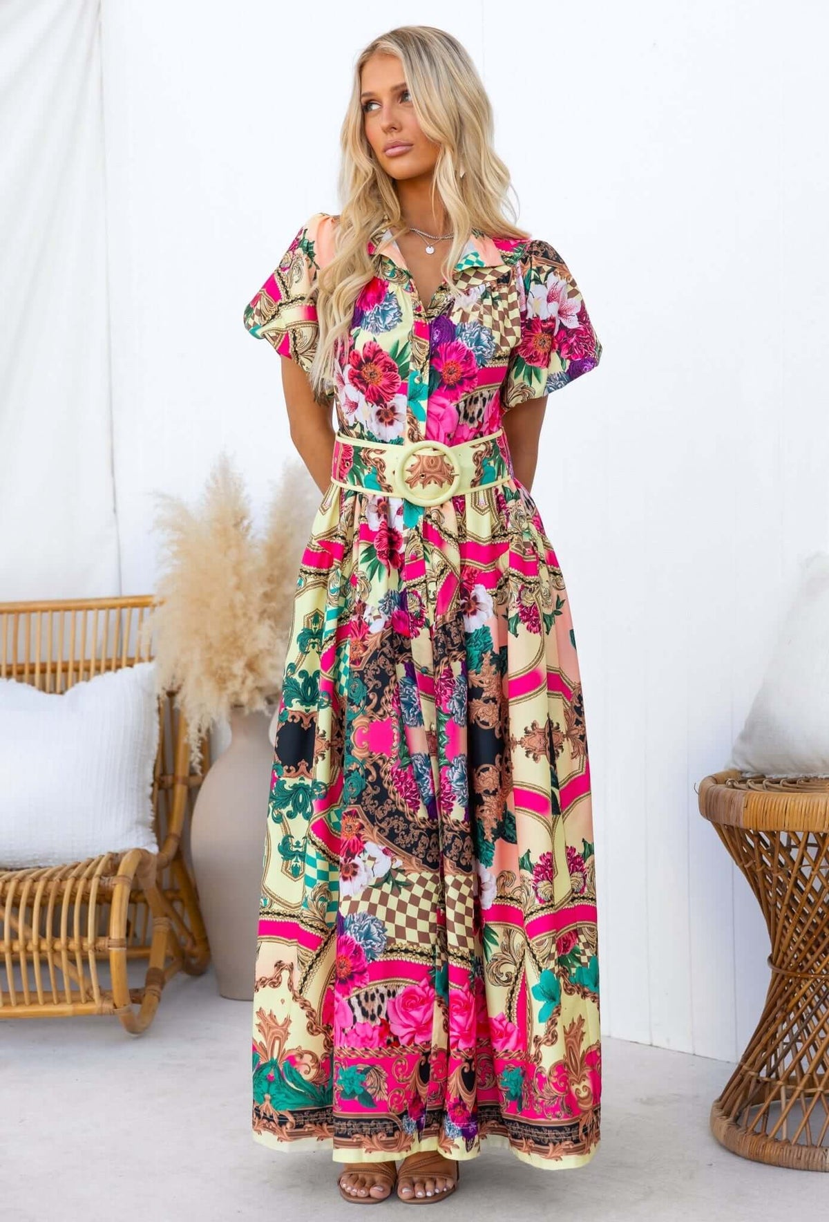 Model wearing Palermo Maxi Dress featuring vibrant floral patterns, removable belt, and button-down front design.