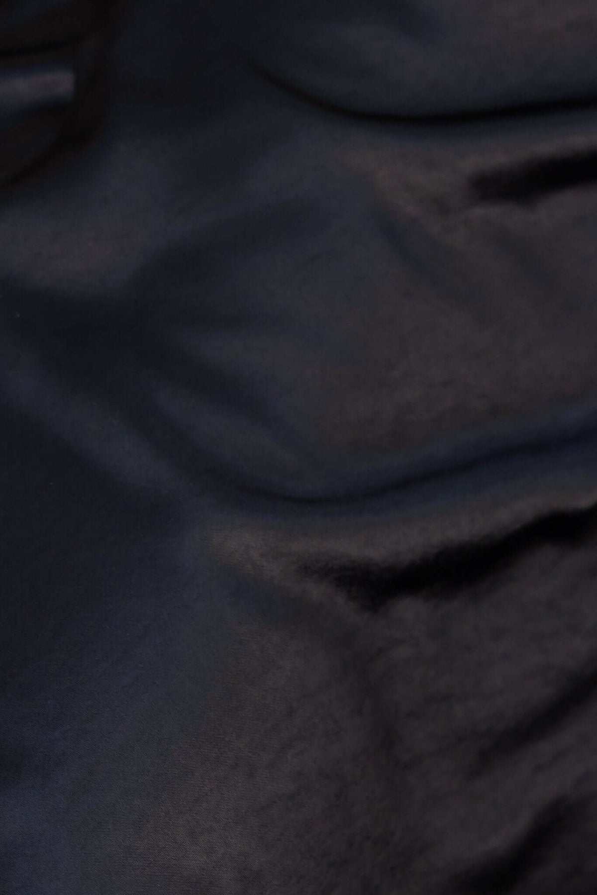 Close-up of black satin material showcasing a soft, luxurious texture for the Brighten My Day Maxi Dress.