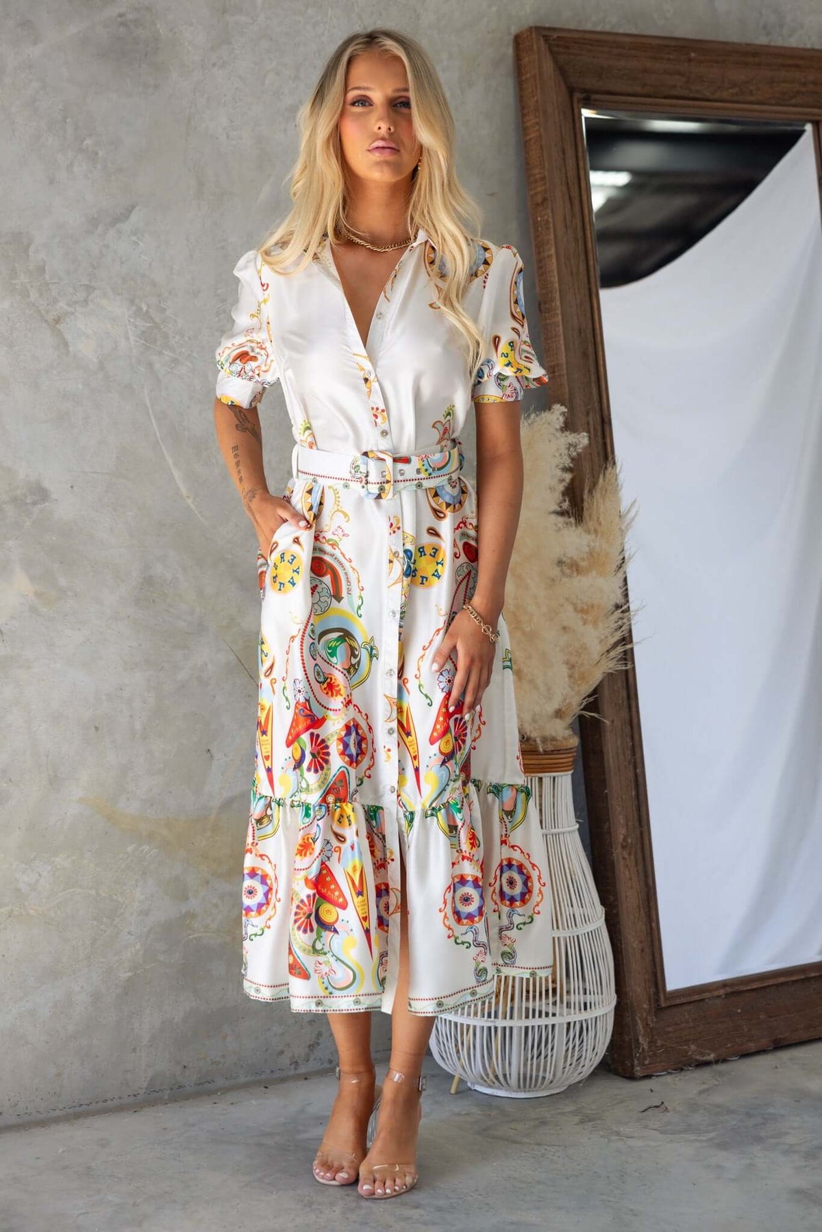 Model wearing Kiton Maxi Dress with colorful floral print, button-down front, and removable belt in stylish setting.