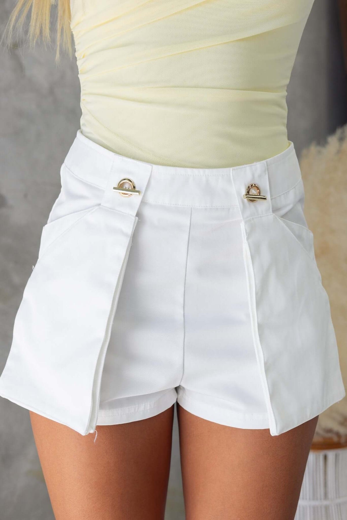 Talia Shorts in white with gold details, mid waist fit, pockets, and a semi-structured fabric.